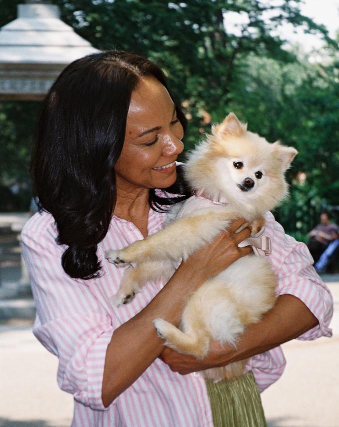 Femme tenant dans ses bras un petit chien poilu, dehors